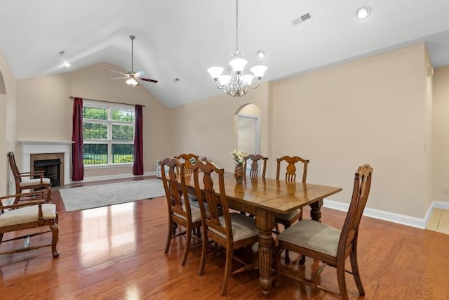 9624 Collier Pl, Ooltewah, TN 37363 - dining space featuring arched walkways, ceiling fan, vaulted ceiling, wood finished floors, and a fireplace