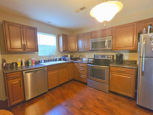 407 W 3rd St, Jasper, TN 37347 - kitchen featuring stainless steel appliances, dark countertops, dark wood-style flooring, and brown cabinets