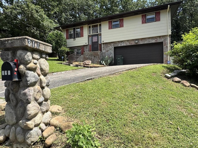 311 Branch Dr, Hixson, TN 37343 - split foyer home featuring a garage, driveway, a front yard, and stone siding