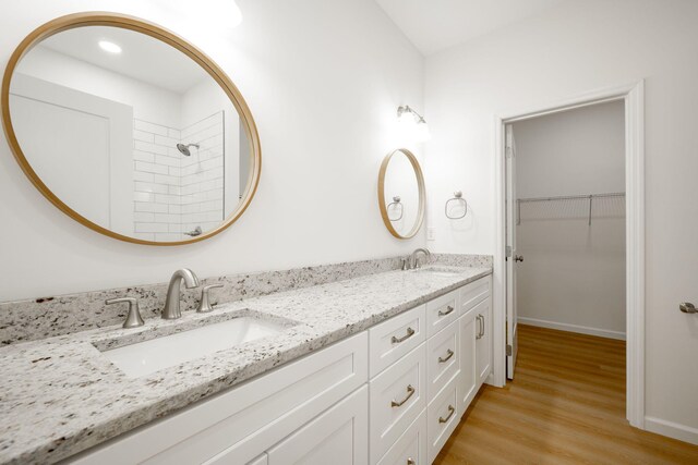 3016 Addison Rd, Chattanooga, TN 37406 - bathroom featuring double vanity, wood finished floors, a spacious closet, and tiled shower