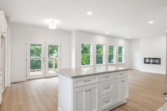 845 James Ave, Chattanooga, TN 37421 - kitchen with light wood-style flooring, white cabinets, recessed lighting, light stone counters, and a center island