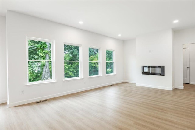 845 James Ave, Chattanooga, TN 37421 - unfurnished living room featuring light wood-type flooring, recessed lighting, heating unit, and a glass covered fireplace