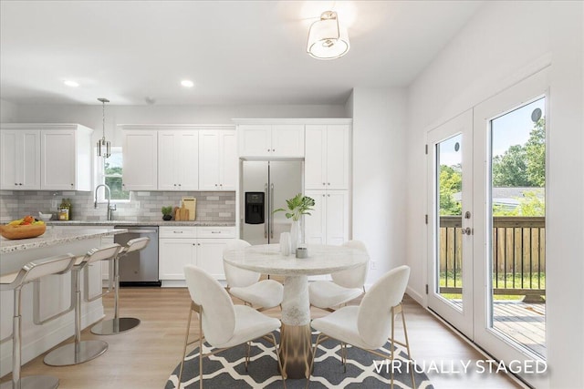 845 James Ave, Chattanooga, TN 37421 - kitchen with appliances with stainless steel finishes, backsplash, light wood-style flooring, white cabinets, and light stone counters