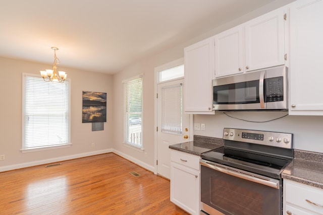 1106 Flynn St, Chattanooga, TN 37403 - kitchen featuring stainless steel appliances, a chandelier, dark countertops, and light wood-style floors