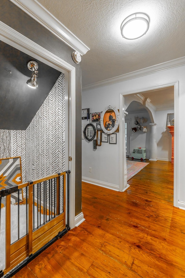 1727 Saunders Rd, Ringgold, GA 30736 - hall featuring arched walkways, wood-type flooring, a textured ceiling, crown molding, and wallpapered walls