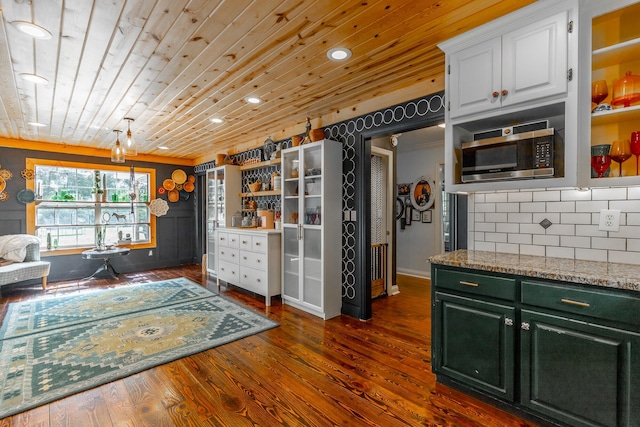 1727 Saunders Rd, Ringgold, GA 30736 - kitchen with stainless steel microwave, dark wood-style floors, backsplash, white cabinets, and wooden ceiling