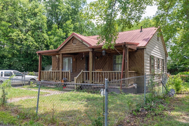 1502 E 49th St, Chattanooga, TN 37407 - chalet / cabin with covered porch, a fenced front yard, and a metal roof