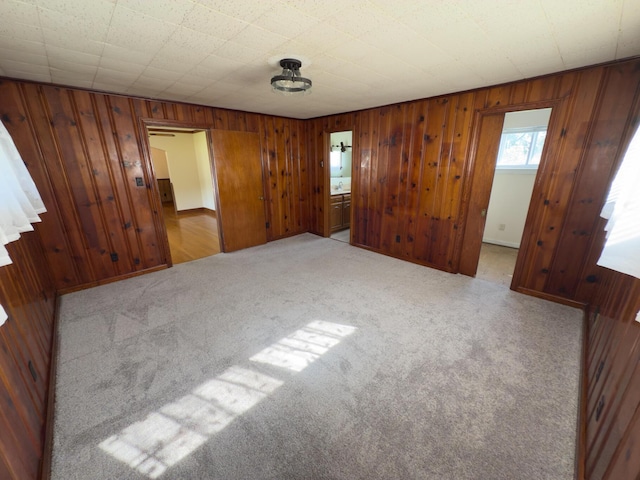 4630 Happy Valley Rd, Flintstone, GA 30725 - unfurnished bedroom featuring light carpet, wood walls, and ensuite bathroom