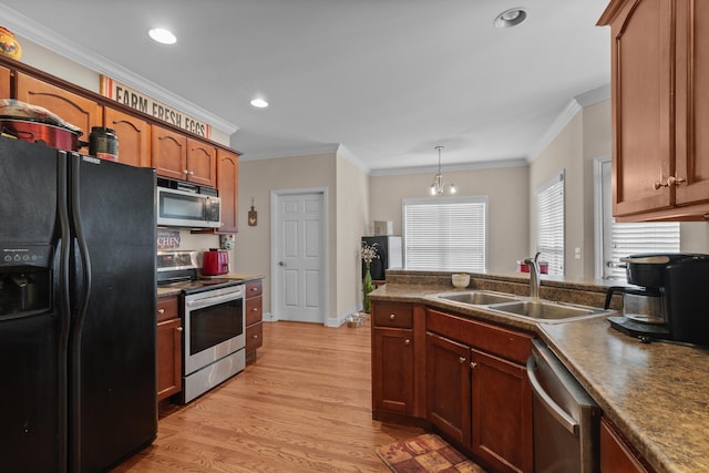 8189 Kaitlin Ln, Ooltewah, TN 37363 - kitchen featuring stainless steel appliances, dark countertops, light wood finished floors, crown molding, and decorative light fixtures