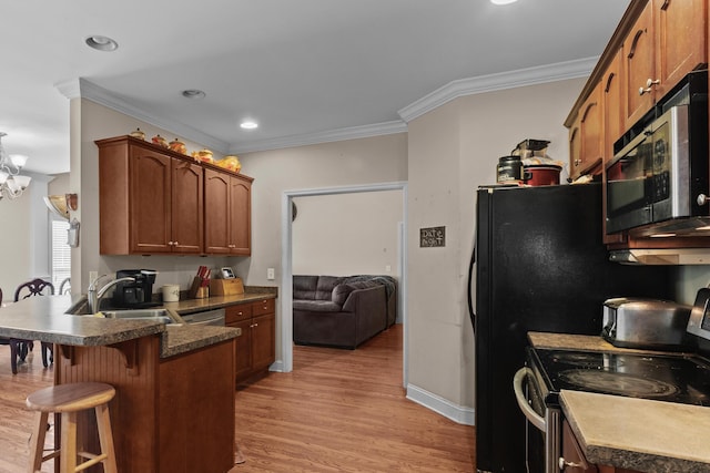 8189 Kaitlin Ln, Ooltewah, TN 37363 - kitchen with stainless steel appliances, a peninsula, a kitchen breakfast bar, ornamental molding, and light wood finished floors