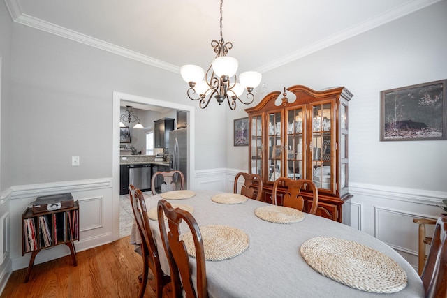 8502 Kennerly Ct, Ooltewah, TN 37363 - dining area featuring a decorative wall, ornamental molding, a chandelier, wood finished floors, and a wainscoted wall