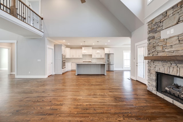 10619 Kavya Ln, Apison, TN 37302 - unfurnished living room with high vaulted ceiling, a stone fireplace, dark wood-style flooring, recessed lighting, and a ceiling fan