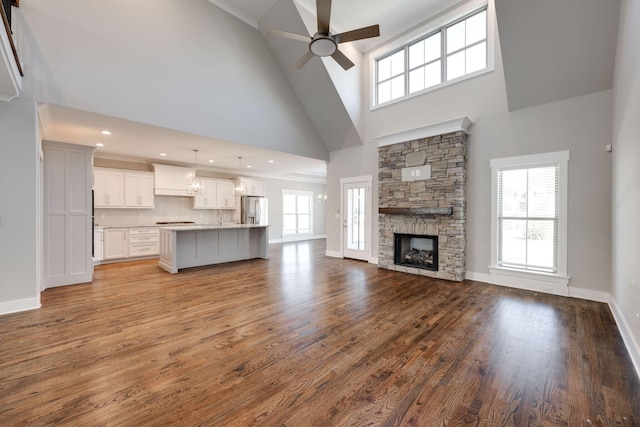 10619 Kavya Ln, Apison, TN 37302 - unfurnished living room featuring high vaulted ceiling, a ceiling fan, wood finished floors, and a fireplace