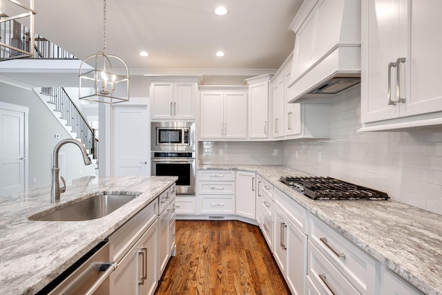 10619 Kavya Ln, Apison, TN 37302 - kitchen with appliances with stainless steel finishes, custom exhaust hood, white cabinets, recessed lighting, and a chandelier