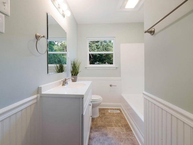 4702 Eldridge Rd, Hixson, TN 37343 - bathroom featuring vanity, stone finish flooring, a wainscoted wall, and a tub to relax in