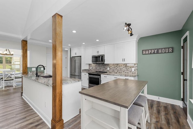 6859 Steep Hl, Ooltewah, TN 37363 - kitchen with stainless steel appliances, open shelves, white cabinets, tasteful backsplash, and a kitchen breakfast bar