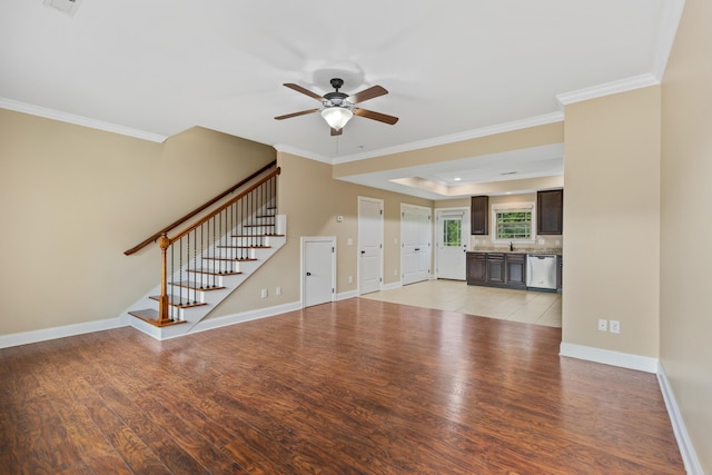 1864 Gate Tower Way NE, Cleveland, TN 37312 - unfurnished living room featuring light wood-type flooring, a ceiling fan, stairway, ornamental molding, and a raised ceiling