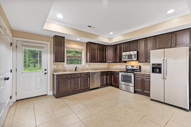 1864 Gate Tower Way NE, Cleveland, TN 37312 - kitchen featuring stainless steel appliances, dark brown cabinetry, light tile patterned flooring, ornamental molding, and light stone counters