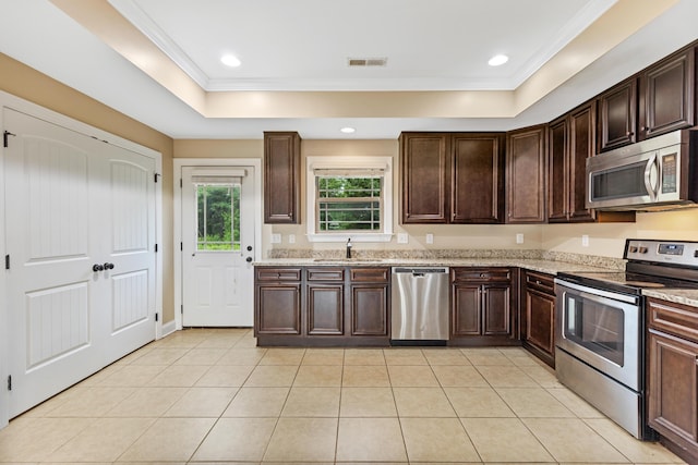 1864 Gate Tower Way NE, Cleveland, TN 37312 - kitchen with appliances with stainless steel finishes, light tile patterned floors, light stone counters, dark brown cabinets, and ornamental molding