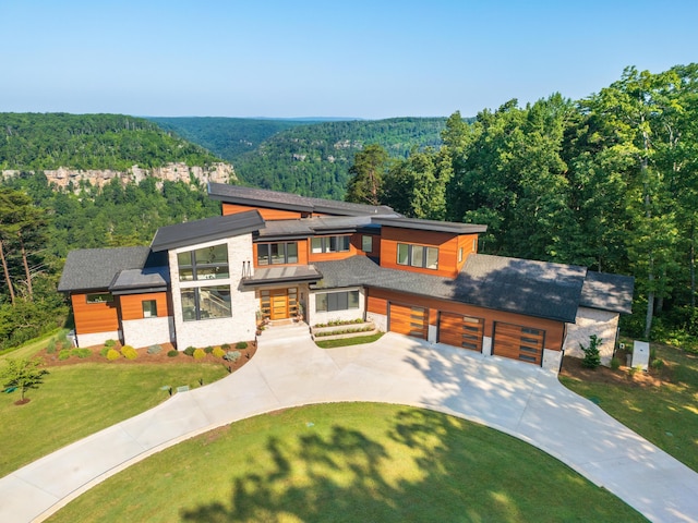1034 Montlake Rd, Soddy Daisy, TN 37379 - contemporary house with a wooded view, concrete driveway, stone siding, and a front lawn