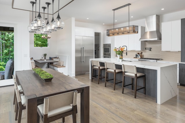 1034 Montlake Rd, Soddy Daisy, TN 37379 - kitchen featuring wall chimney range hood, stainless steel appliances, a large island, decorative backsplash, and a chandelier