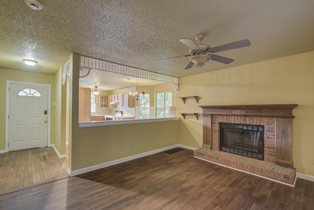 9028 Warbler Ln, Chattanooga, TN 37421 - unfurnished living room with a textured ceiling, a ceiling fan, wood finished floors, and a fireplace