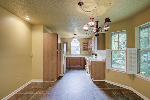 9028 Warbler Ln, Chattanooga, TN 37421 - kitchen with white appliances, healthy amount of natural light, a chandelier, a textured ceiling, and light countertops