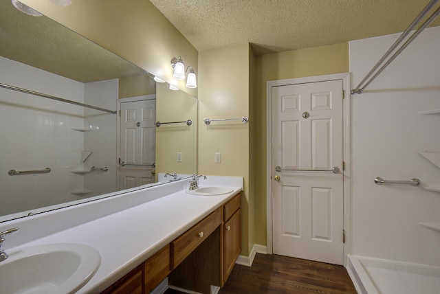 9028 Warbler Ln, Chattanooga, TN 37421 - full bathroom featuring wood finished floors, a textured ceiling, double vanity, and a shower