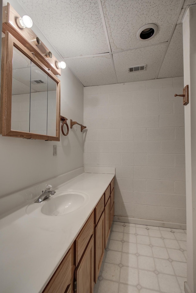 9028 Warbler Ln, Chattanooga, TN 37421 - bathroom with tile patterned floors, a paneled ceiling, vanity, and concrete block wall