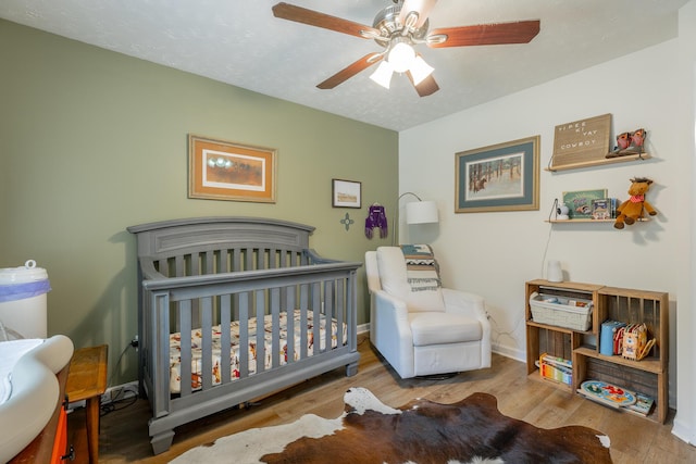 171 Gentry Rd, Ringgold, GA 30736 - bedroom with a crib, wood finished floors, and ceiling fan