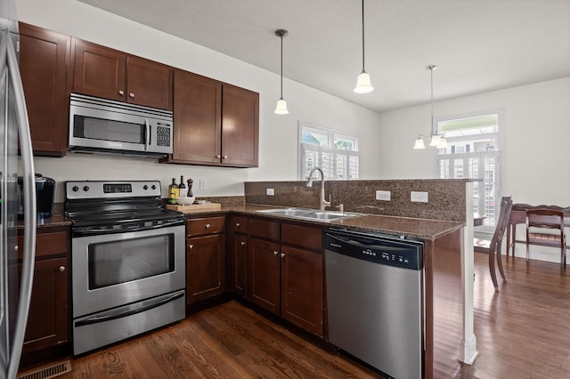 509 E 16th St, Chattanooga, TN 37408 - kitchen with stainless steel appliances, a peninsula, dark wood-style flooring, and a chandelier