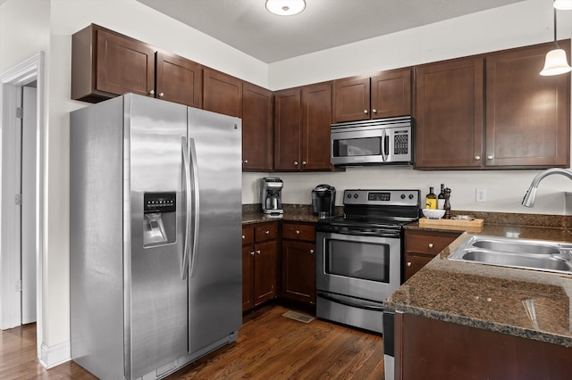 509 E 16th St, Chattanooga, TN 37408 - kitchen with appliances with stainless steel finishes, dark wood-type flooring, dark brown cabinets, and dark stone counters