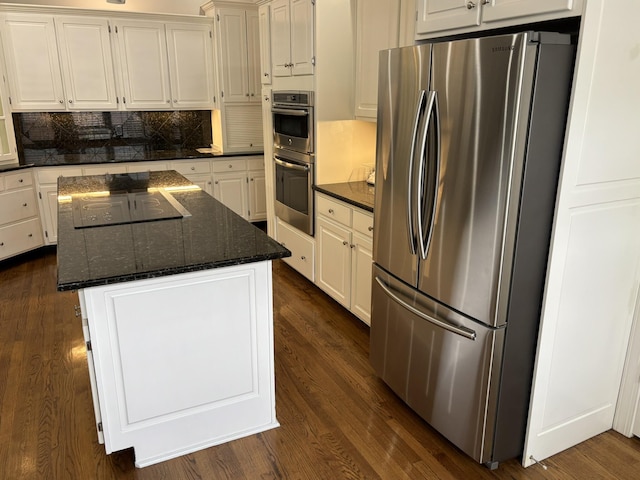 6419 Camdendown Ln, Hixson, TN 37343 - kitchen featuring appliances with stainless steel finishes, a center island, backsplash, dark stone countertops, and dark wood-style flooring