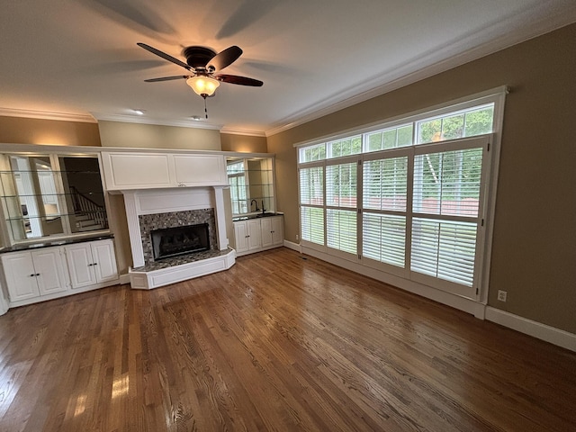 6419 Camdendown Ln, Hixson, TN 37343 - unfurnished living room featuring ornamental molding, a ceiling fan, a fireplace, dark wood finished floors, and healthy amount of natural light