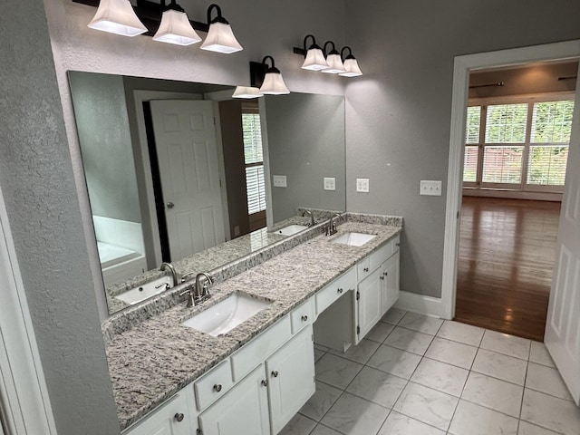 6419 Camdendown Ln, Hixson, TN 37343 - bathroom featuring double vanity, a textured wall, and a tub to relax in