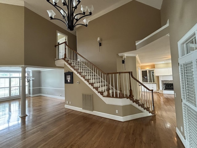 6419 Camdendown Ln, Hixson, TN 37343 - stairway with a high ceiling, a chandelier, wood finished floors, a fireplace with raised hearth, and ornamental molding