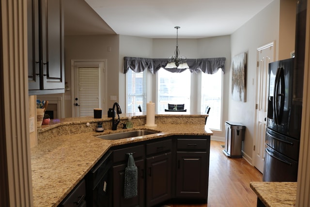 7354 Kayla Beth Ct, Ooltewah, TN 37363 - kitchen featuring black refrigerator with ice dispenser, light stone countertops, light wood finished floors, a peninsula, and a chandelier