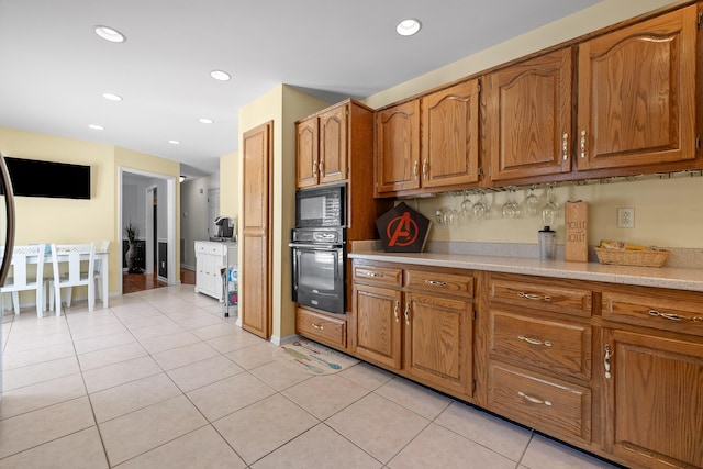 8014 Woodstone Dr, Hixson, TN 37343 - kitchen with black appliances, brown cabinets, light countertops, light tile patterned floors, and recessed lighting