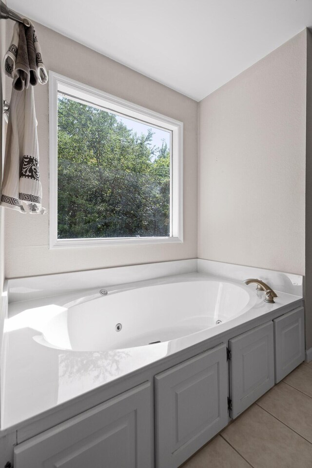 8014 Woodstone Dr, Hixson, TN 37343 - bathroom featuring healthy amount of natural light, tile patterned flooring, and a tub with jets