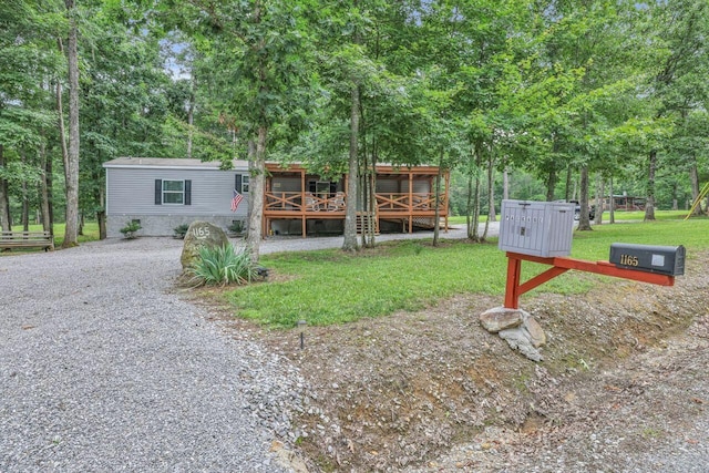 1165 Hugh Allison, Pikeville, TN 37367 - view of front of home with gravel driveway, a front lawn, a deck, and view of scattered trees