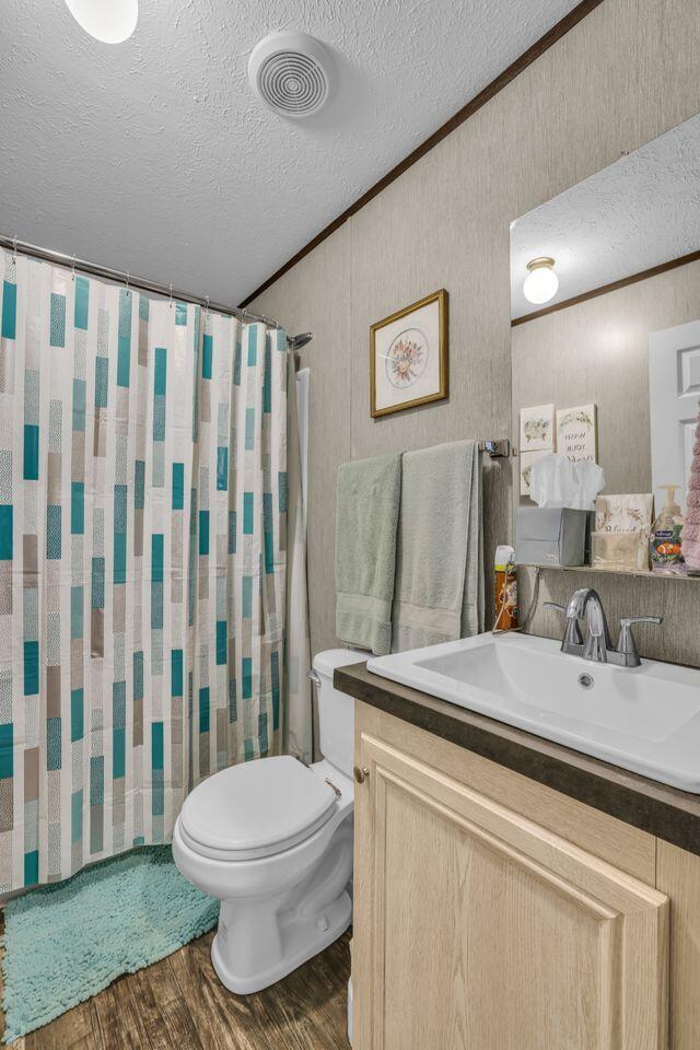 1165 Hugh Allison, Pikeville, TN 37367 - full bath featuring wood finished floors, a textured ceiling, vanity, crown molding, and a shower with curtain