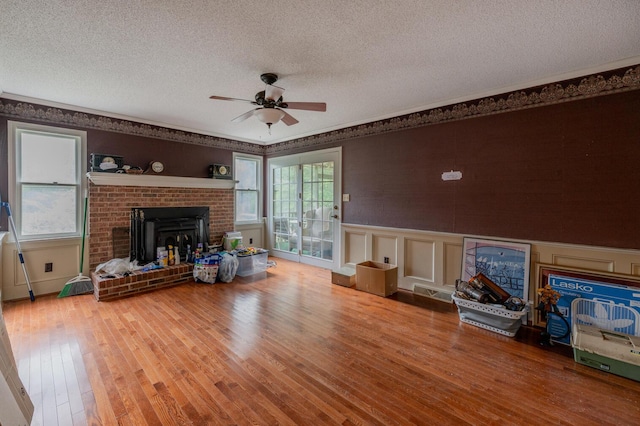 200 Whippoorwill Ln, Lafayette, GA 30728 - living area with a textured ceiling, a ceiling fan, wood finished floors, a fireplace, and a wainscoted wall