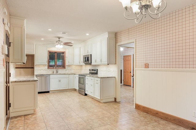 1920 Campbell Dr NW, Cleveland, TN 37312 - kitchen featuring stainless steel appliances, a chandelier, light stone countertops, a wainscoted wall, and backsplash