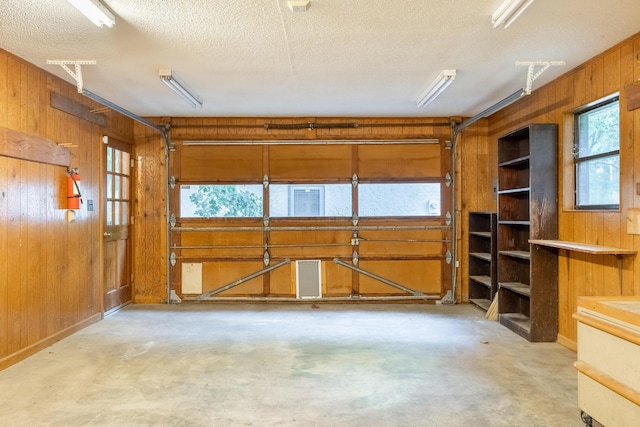 1920 Campbell Dr NW, Cleveland, TN 37312 - misc room featuring a garage, wooden walls, unfinished concrete flooring, and a textured ceiling