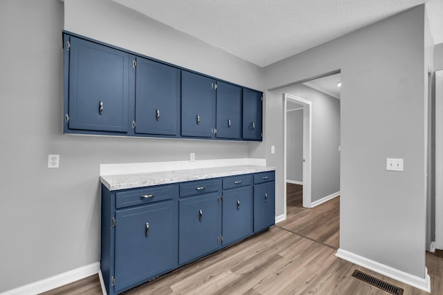 5506 Sunny Dell Ln, Chattanooga, TN 37412 - kitchen featuring blue cabinetry, light wood-style floors, light countertops, and a textured ceiling