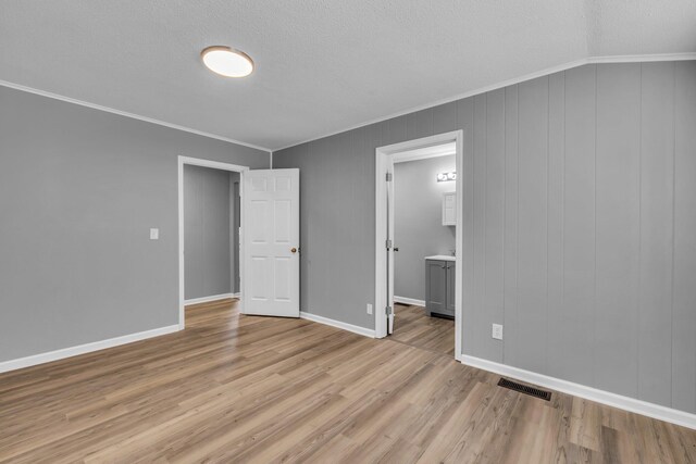 5506 Sunny Dell Ln, Chattanooga, TN 37412 - unfurnished bedroom featuring ornamental molding, light wood-type flooring, a textured ceiling, and ensuite bathroom