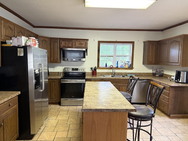 210 Laurel Ave, South Pittsburg, TN 37380 - kitchen featuring appliances with stainless steel finishes, a kitchen island, a breakfast bar area, and ornamental molding