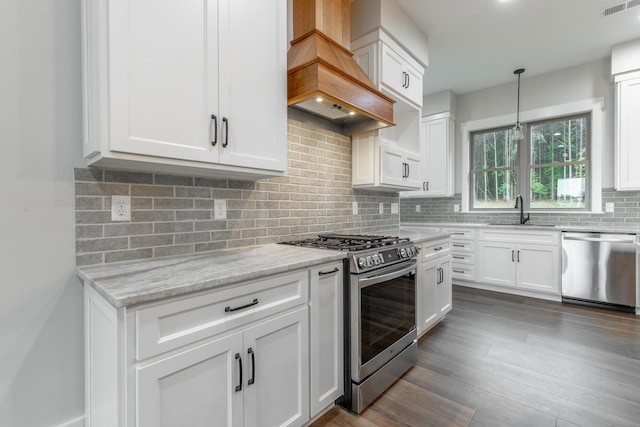 220 High Point Ln, Jasper, TN 37347 - kitchen with stainless steel appliances, custom range hood, white cabinets, light stone countertops, and decorative backsplash