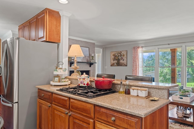 4522 Cloverdale Loop, Hixson, TN 37343 - kitchen with freestanding refrigerator, gas cooktop, crown molding, brown cabinets, and light stone counters