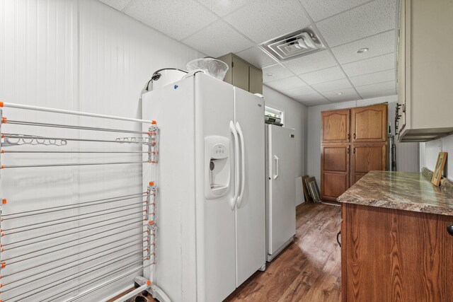 4522 Cloverdale Loop, Hixson, TN 37343 - kitchen featuring white fridge with ice dispenser, a drop ceiling, freestanding refrigerator, dark wood-style floors, and brown cabinetry